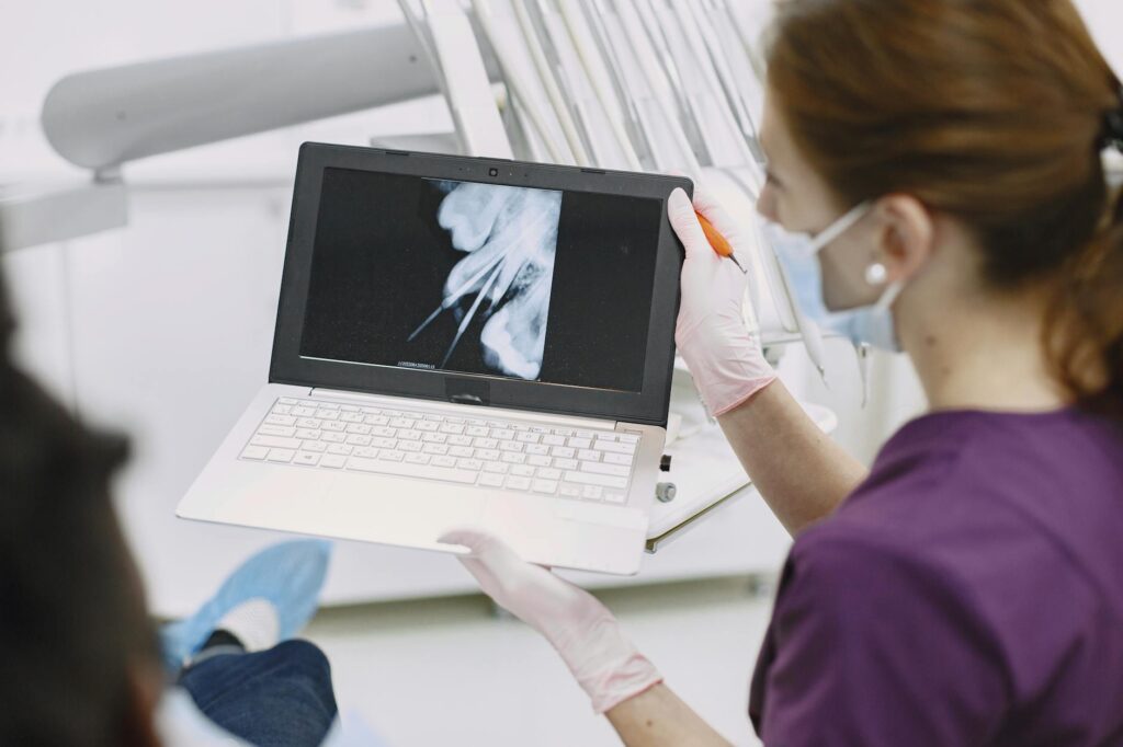 Dentist examining patient's teeth using dental mirror.