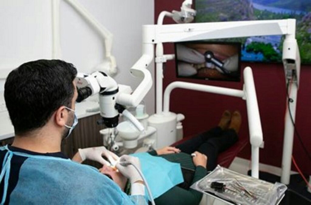 Dentist using a microscope to examine a patient.
