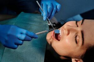 Dentist examining a patient's teeth with a mirror.