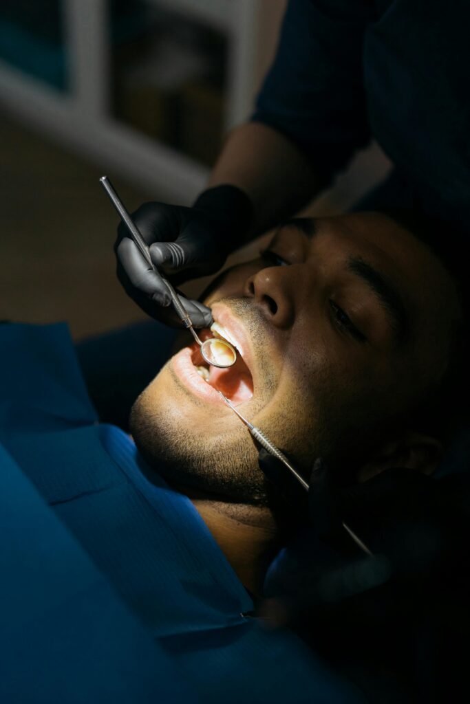 Dentist examining a patient's mouth with dental tools.