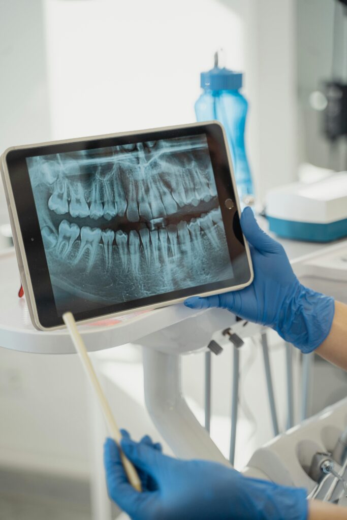 Dentist holding a tablet displaying a dental X-ray.