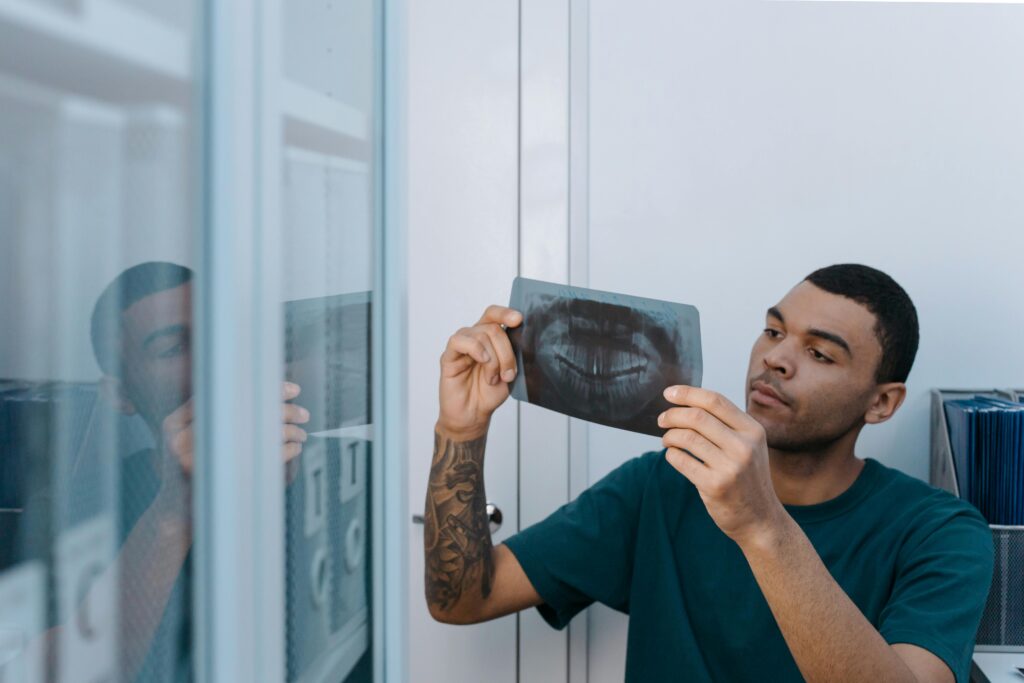 Person examining a dental X-ray in an office setting.
