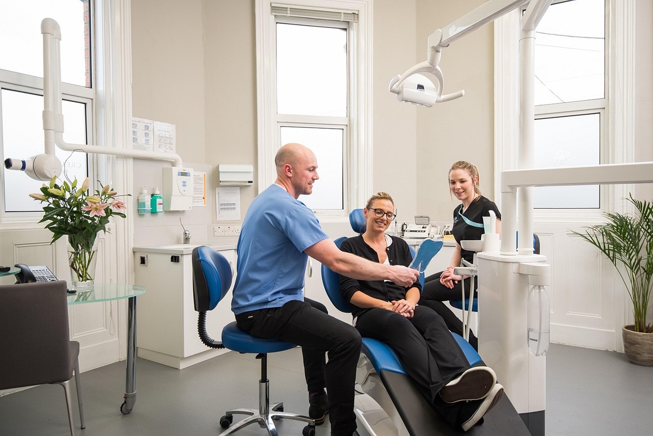 Dentist showing a mirror to a patient in a dental office.