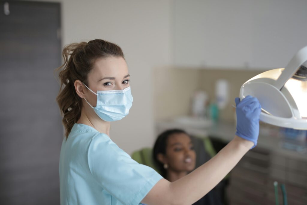 Healthcare professional adjusting a dental light in an office.