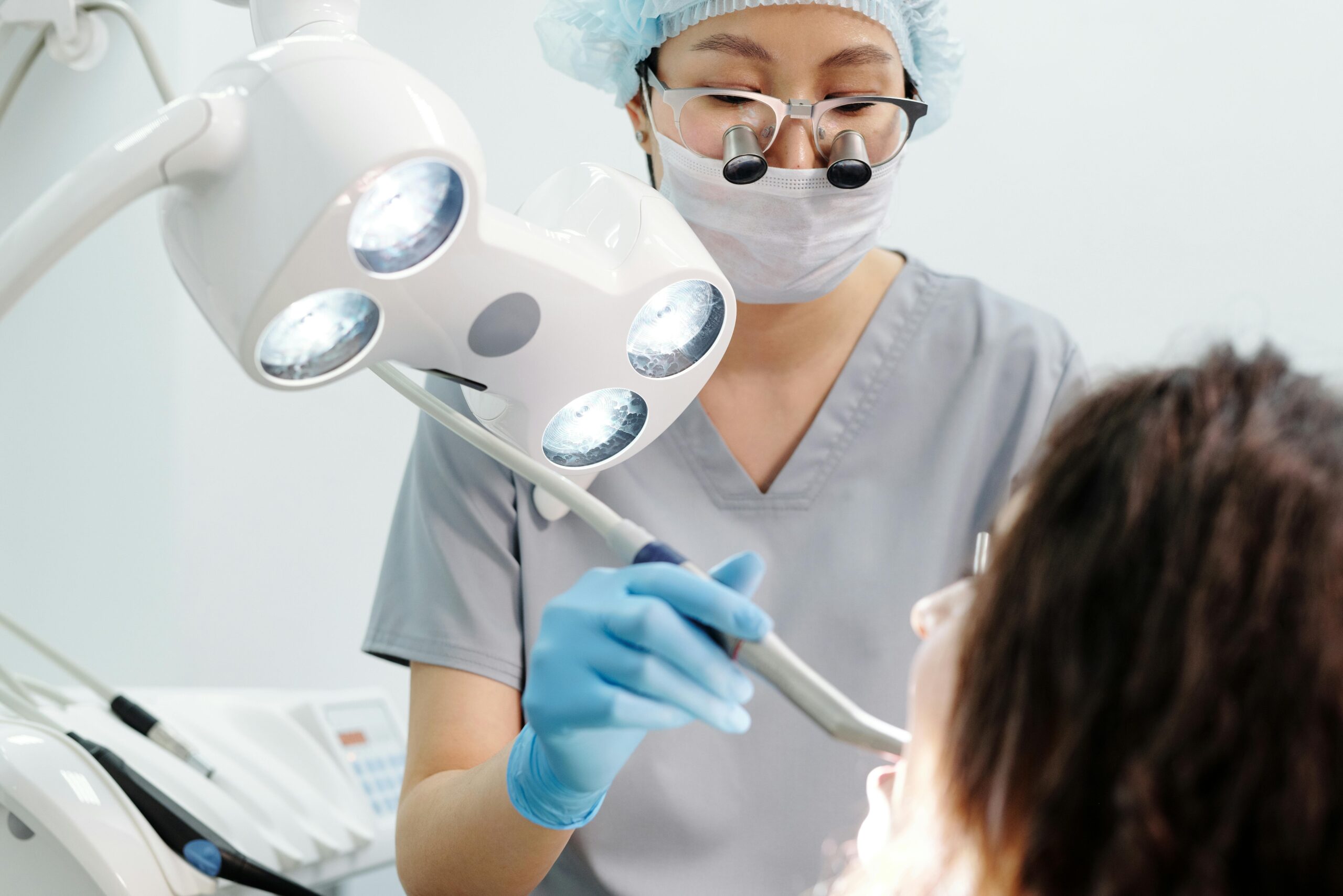 Dentist wearing magnifying glasses working on a patient.