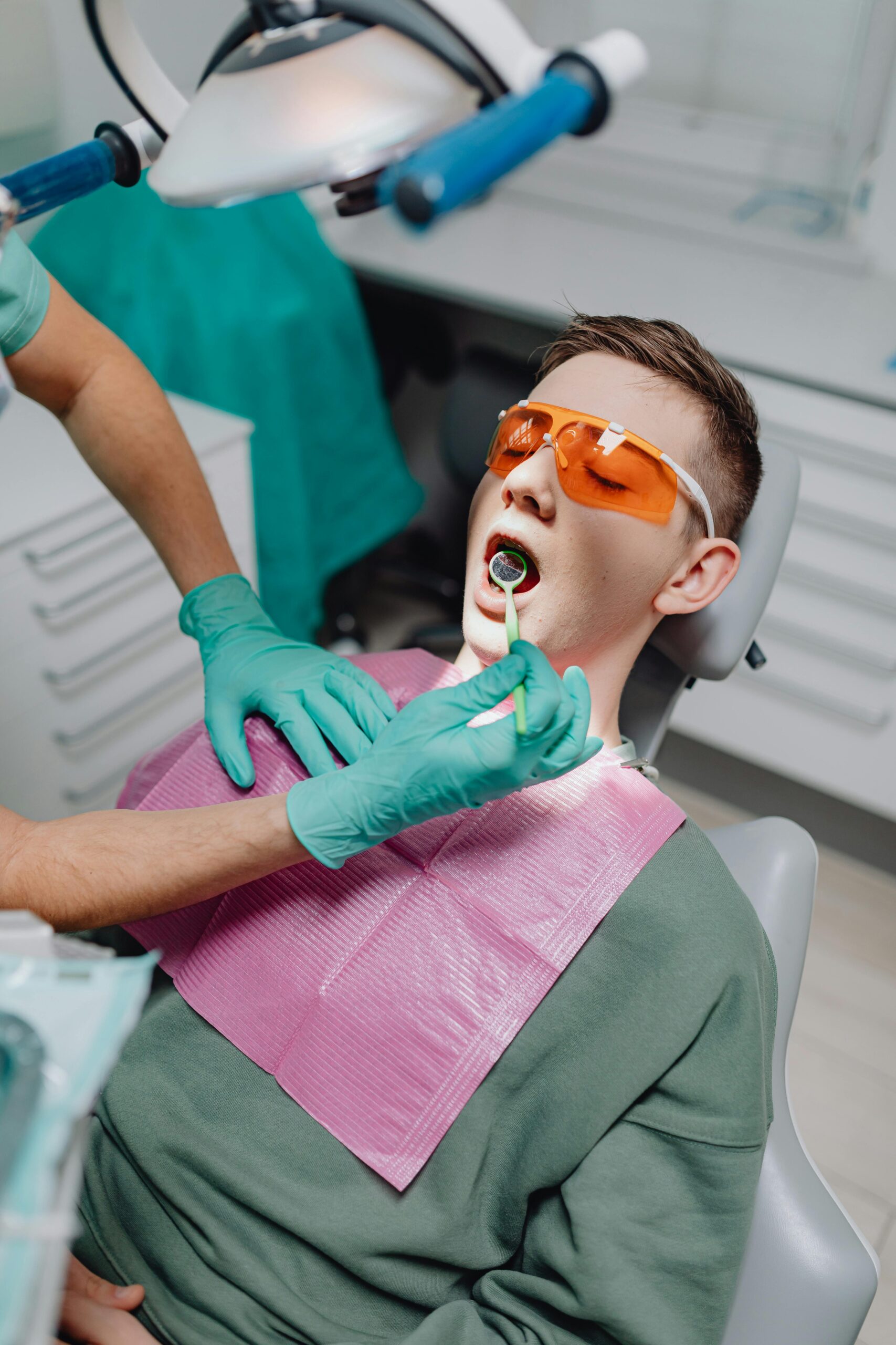 Dentist examining a patient's mouth with dental tools.