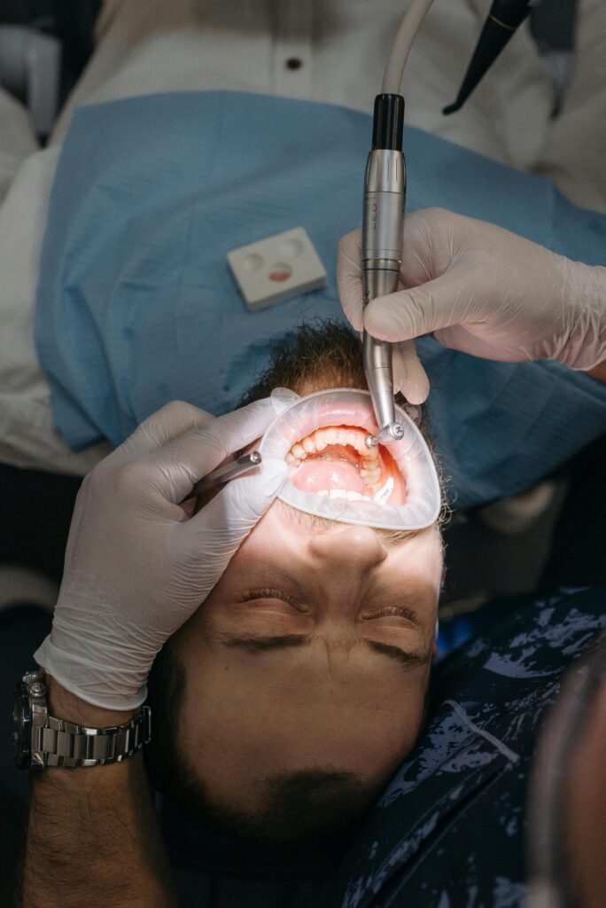 Dentist performing a procedure on a patient with dental tools.