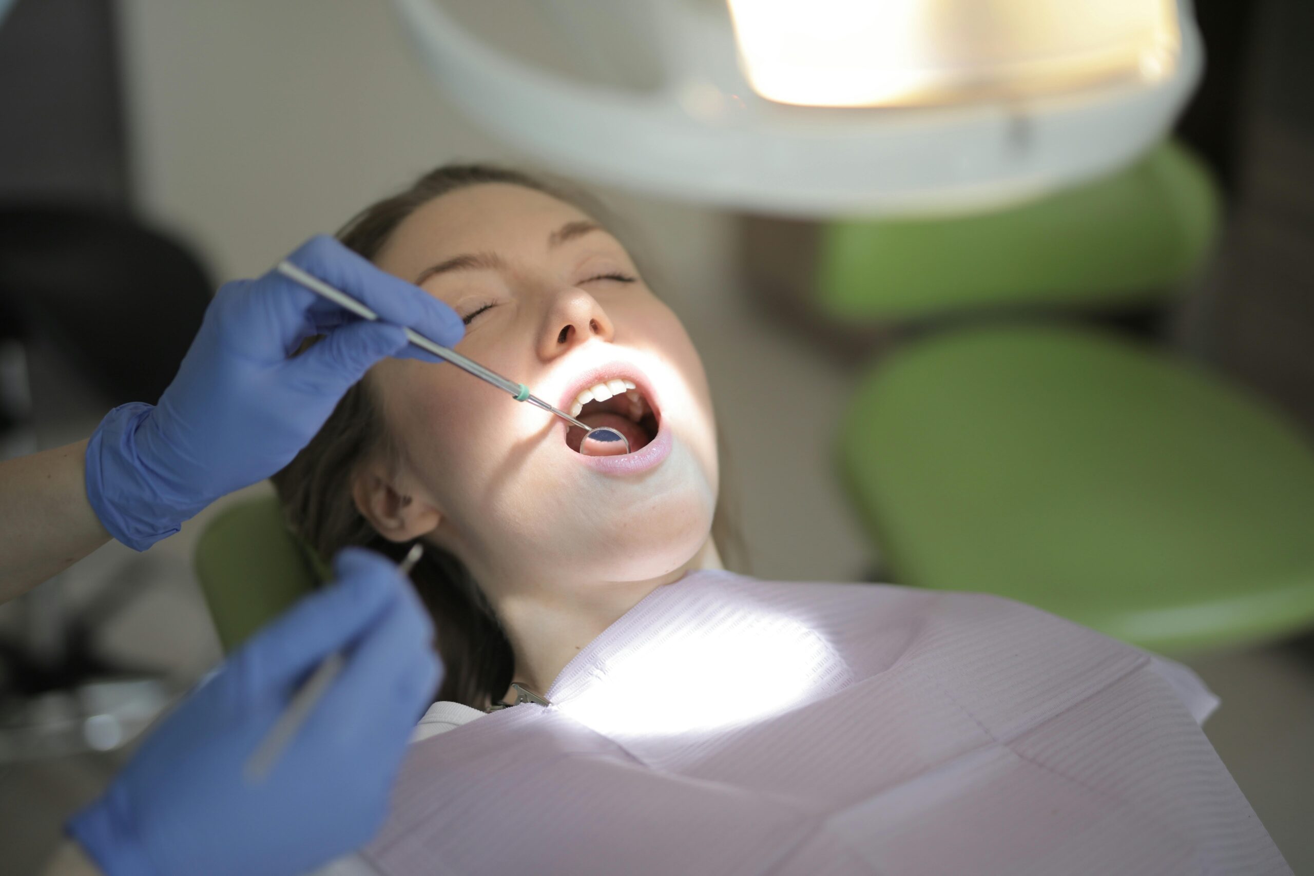 Dentist examining a patient's teeth with tools.