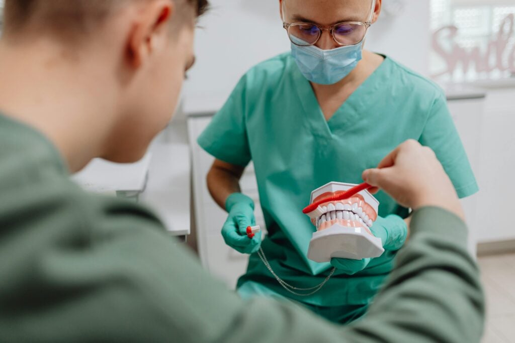 Dentist demonstrating brushing on a dental model.