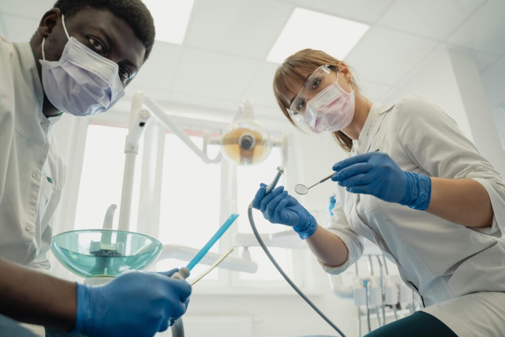 Two dentists holding dental tools in a clinic setting.
