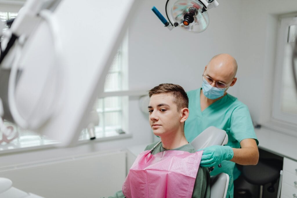 Dentist adjusting a patient in a dental chair.